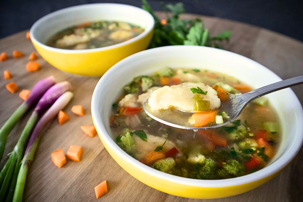 A bowl of Balkan vegan dumpling soup with soft semolina dumplings and vegetables